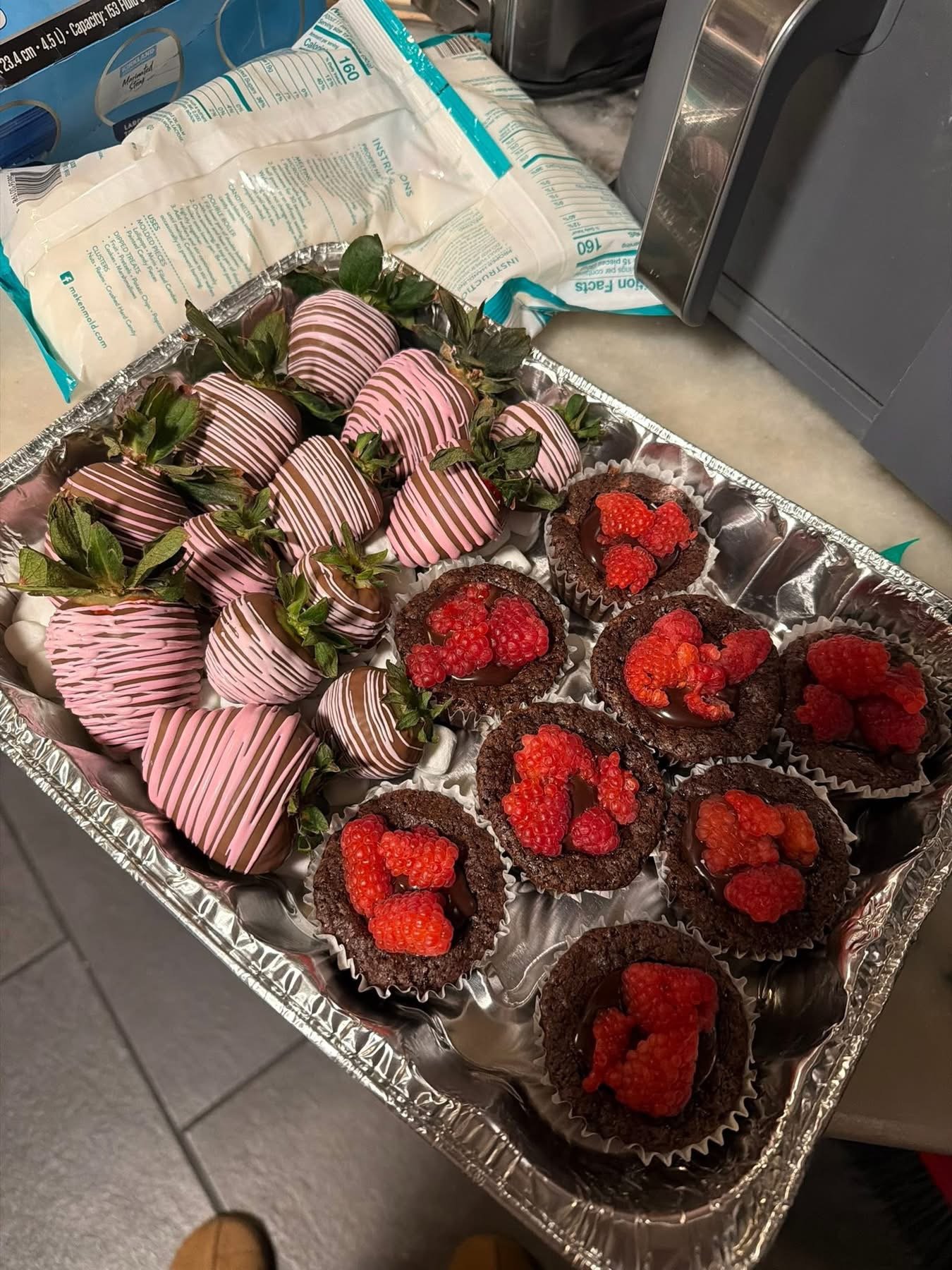 Tray of chocolate-covered strawberries and raspberry chocolate tarts